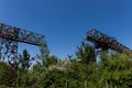 Part two rusty gantry cranes on the background of blue sky.