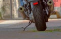 Part of the tyre and exhaust pipes of a parked motorcycle, selective focus