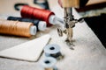 Part of a vintage sewing machine and item of clothing. Steel needle with looper and presser foot close-up. Royalty Free Stock Photo