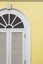 Vintage white wooden arch window on yellow cement wall background Royalty Free Stock Photo