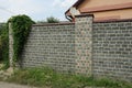 Part of a wall of a fence made of black gray stones and bricks Royalty Free Stock Photo