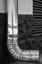 Part of wall with galvanized pipe for draining rainwater. Side view. Black and white photo. Close-up. Royalty Free Stock Photo