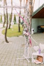 Part of the wedding arch decorated with flowers and ribbons near the wooden crates with hearts.