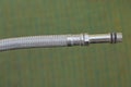 Part of a white metal hose with a gray threaded iron tube