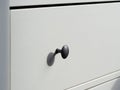 Part of a white modern wooden chest of drawers Royalty Free Stock Photo