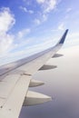 Traveling by plane. View from the window to the clouds and blue sky.