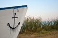 Part of a wooden boat with a anchore drawed