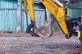 Part of a yellow excavator with a gray iron dirty bucket