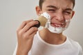 Partial of boy smearing shaving foam on face