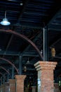 A partial close-up of the roof and top beam pillars of a retro train station