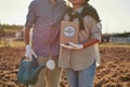 Partial of farmer couple with water can and seeds