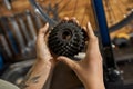 Partial of female mechanic holding bike cassette