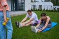 Partial girl near parents doing crunching on green yard near modern townhouse Royalty Free Stock Photo