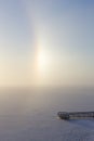 Partial halo and pier at a frozen & snowy lake