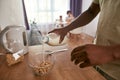 Partial of man pouring milk in bowl with cereals