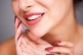 Partial portrait of woman smiling with red manicure and flawless complexion