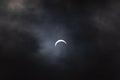 Partial solar eclipse - moon covers sun, dark clouds, celestial drama - crescent sun - atmospheric mood Royalty Free Stock Photo