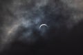 Partial solar eclipse - moon covers sun, dark clouds, celestial drama - crescent sun - atmospheric mood Royalty Free Stock Photo