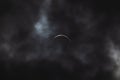 Partial solar eclipse - moon covers sun, dark clouds, celestial drama - crescent sun - atmospheric mood Royalty Free Stock Photo