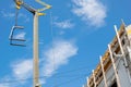 partial view of the attic of a house under construction and crane in a blue sky day Royalty Free Stock Photo