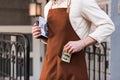 View of barista in brown apron putting money in pocket Royalty Free Stock Photo