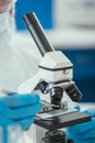 View of biochemist looking through microscope at small stone