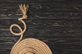 partial view of brown knotted nautical rope arranged in circle on wooden surface