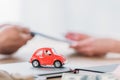 View of businessman and customer near red toy car in office