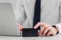 partial view of businessman holding black empty business card while sitting at workplace in office. Royalty Free Stock Photo