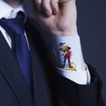 A partial view of a businessman with a Joker card in a sleeve as