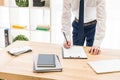 partial view of businessman signing papers at workplace with notebooks Royalty Free Stock Photo