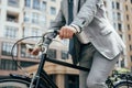 partial view of businessman in suit biking