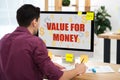 partial view of businessman working on computer with value for money inscription on screen at workplace Royalty Free Stock Photo