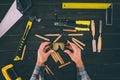 partial view of carpenter holding goggles in hands with various industrial tools around Royalty Free Stock Photo