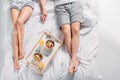 partial view of couple with breakfast on wooden tray resting Royalty Free Stock Photo