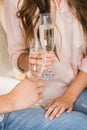 partial view of couple clinking glasses of champagne on sofa Royalty Free Stock Photo