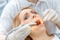 Partial view of dentist curing scared patient looking at camera Royalty Free Stock Photo