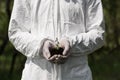 View of ecologist in latex gloves holding handful of soil with dayflowers