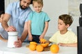 partial view of family making fresh orange juice together in kitchen Royalty Free Stock Photo