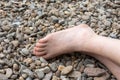 Partial view of a human bare foot on pebbles Royalty Free Stock Photo