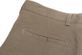 Partial view of a kaki brown back pocket area of a pair of casual pants