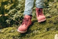 partial view of little child in pink autumn shoes walking