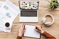 partial view of man making notes in notebook at workplace with laptop with pinterest website, papers, cup of coffee Royalty Free Stock Photo