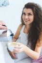 partial view of man pouring coffee to beautiful smiling woman