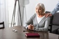 View of man supporting senior mother with wooden rosary Royalty Free Stock Photo