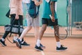 partial view of multicultural elderly men with tennis equipment walking