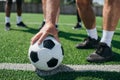 partial view of old player holding football ball with multiracial friends behind Royalty Free Stock Photo