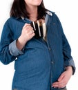 Woman in blue denim shirt holding dark glass cup with tea and touching belly isolated on white