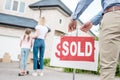 partial view of realtor hanging sold sign in front of people moving into new Royalty Free Stock Photo