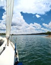 partial view of sailing boat on lake with blue sky with clouds and horizon in background Royalty Free Stock Photo